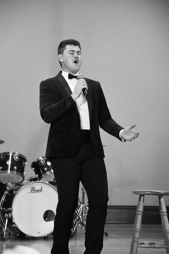 Dylan singing on stage in a tuxedo, black and white