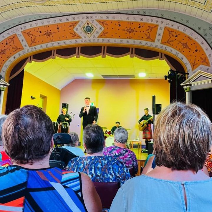 Audience watching Dylan Forge perform in a country hall