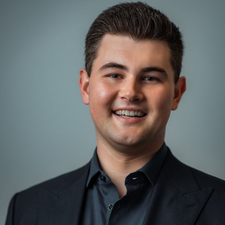 Smiling portrait of Dylan Forge in a dark suit