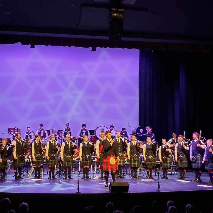 Dylan Forge on a theatre stage with a pipe band