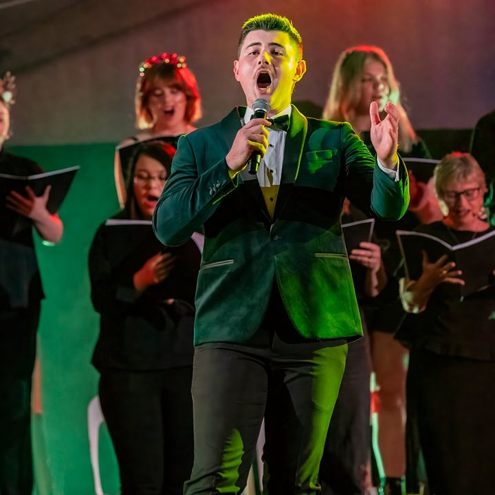 Dylan Forge singing with a choir at Carols by Candlelight