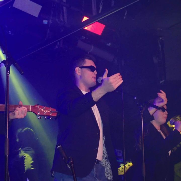 Dylan Forge performing with a band at a live music venue